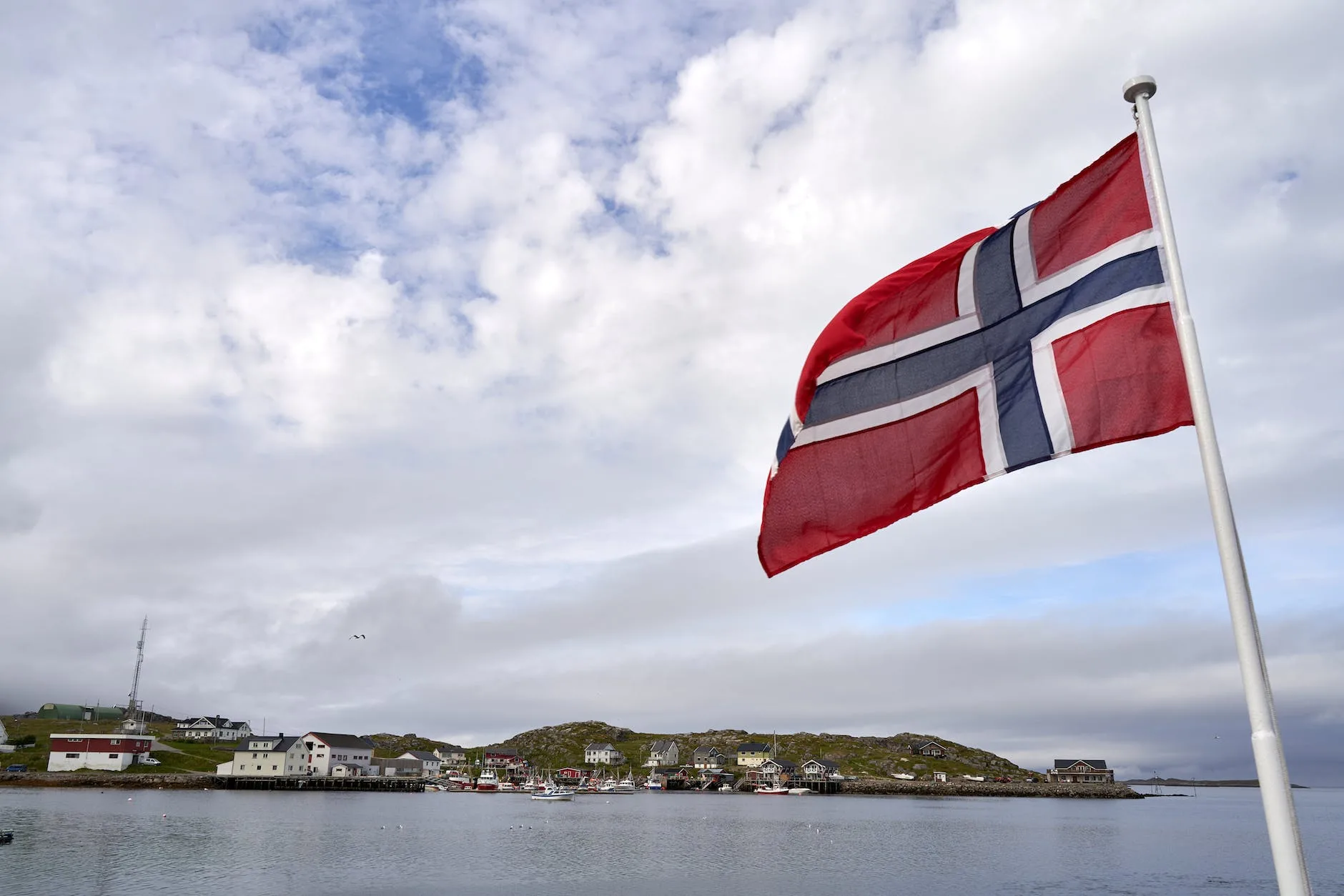 norway flag on pole near body of water
