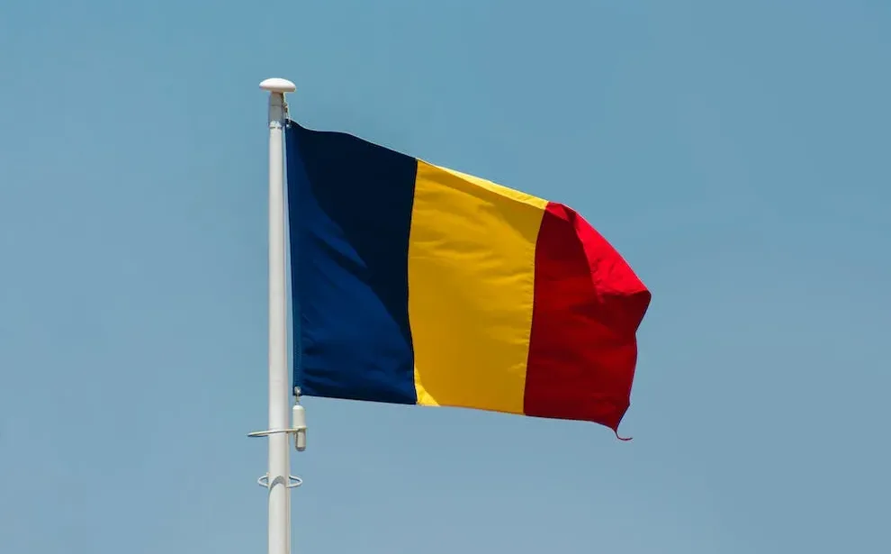 the flag of romania on a flag pole